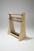 Wooden wall-mounted storage rack with multiple shelves on a black background